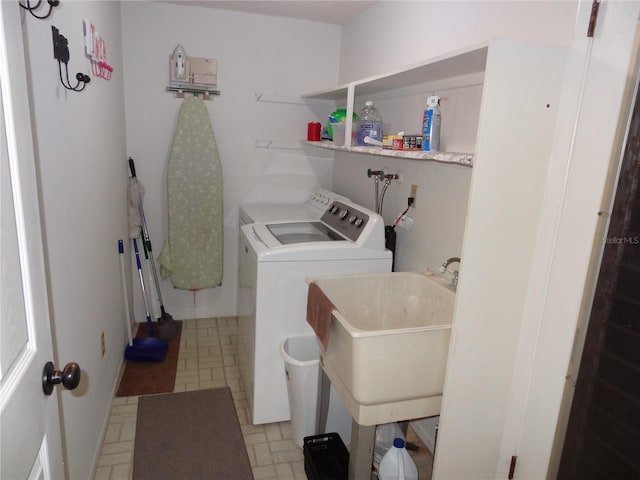 clothes washing area featuring separate washer and dryer and sink