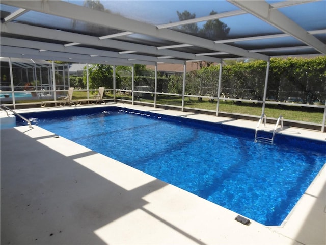 view of swimming pool featuring glass enclosure and a patio