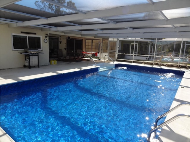 view of swimming pool with area for grilling, a patio area, and a lanai