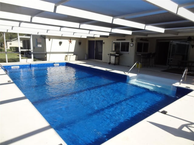 view of pool featuring glass enclosure, area for grilling, and a patio