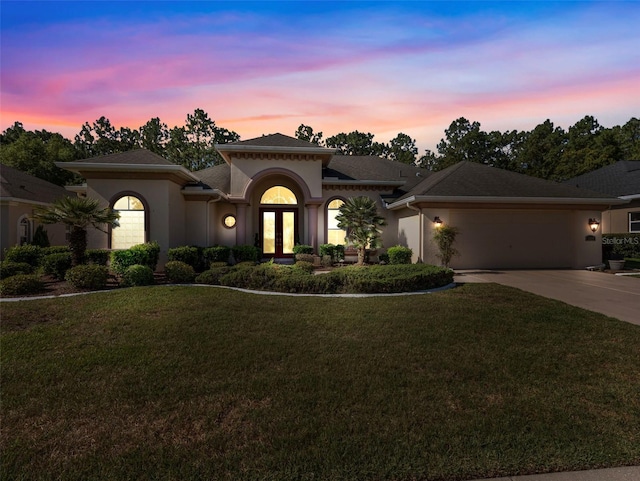 view of front of house with a yard, french doors, and a garage