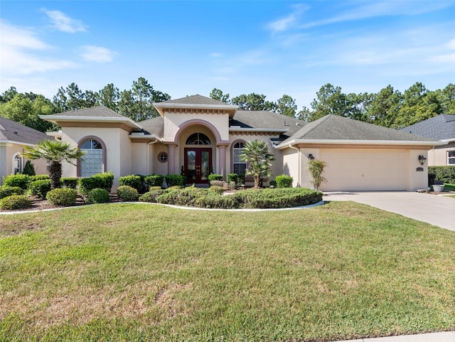 mediterranean / spanish-style home featuring a front yard, french doors, and a garage