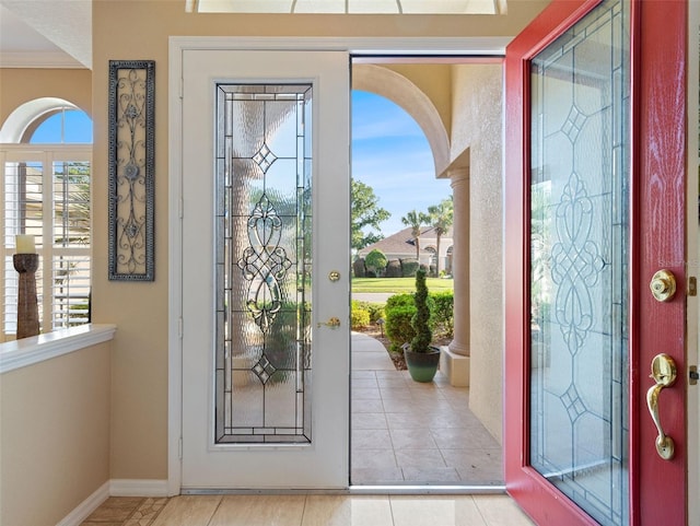 tiled foyer entrance featuring ornamental molding