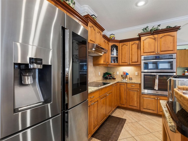 kitchen with backsplash, light stone countertops, ornamental molding, light tile patterned floors, and stainless steel appliances