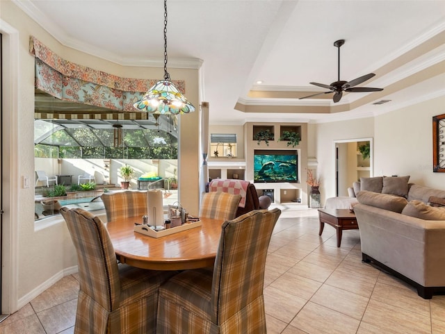 dining room with ceiling fan, ornamental molding, light tile patterned floors, and a tray ceiling