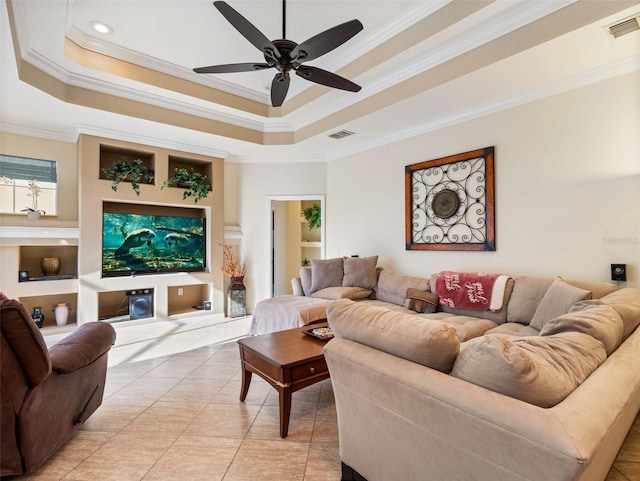 living room featuring built in shelves, a raised ceiling, and ceiling fan