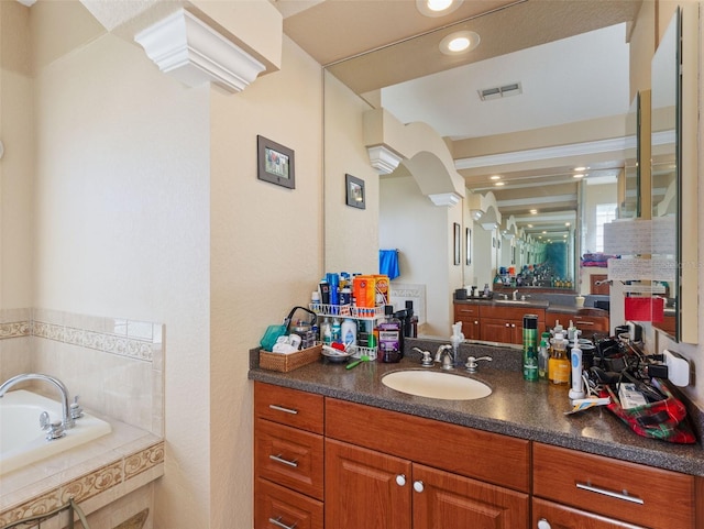 bathroom featuring vanity and tiled bath