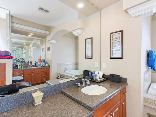 bathroom with a washtub and vanity