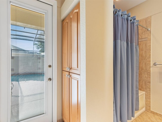 bathroom with tile patterned floors and shower / bathtub combination with curtain