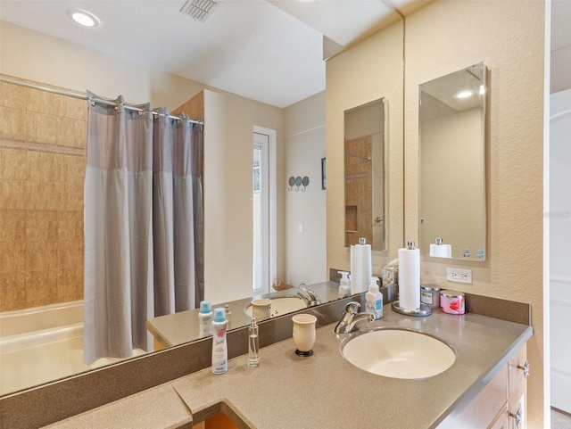 bathroom featuring shower / bath combo and vanity