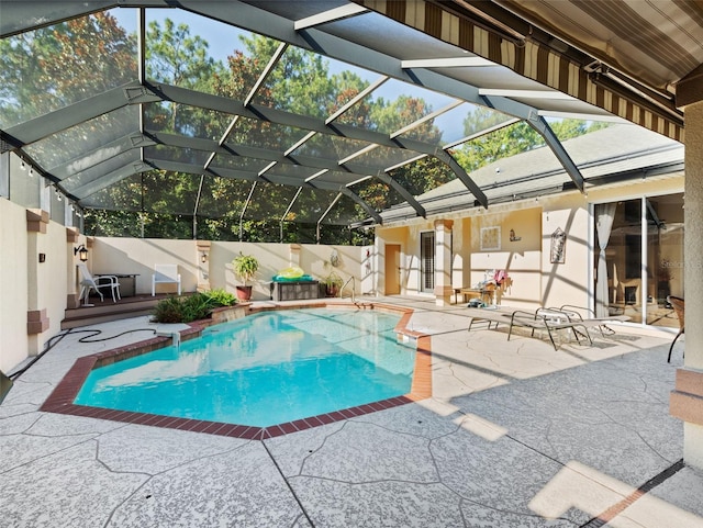 view of pool with glass enclosure and a patio