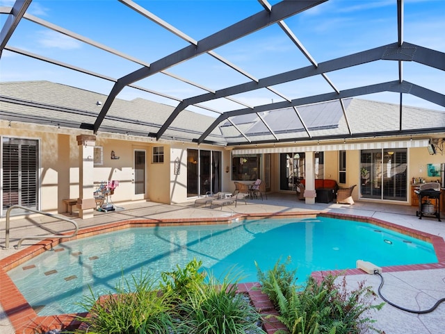 view of pool with glass enclosure and a patio area