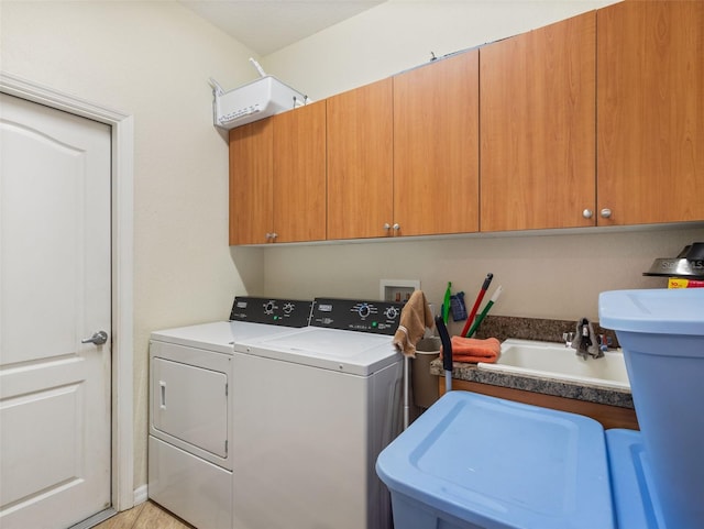 laundry area with separate washer and dryer, sink, and cabinets