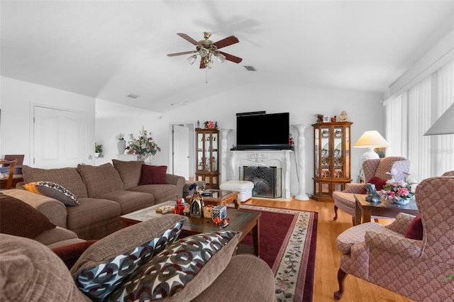 living room featuring hardwood / wood-style flooring, ceiling fan, lofted ceiling, and a premium fireplace