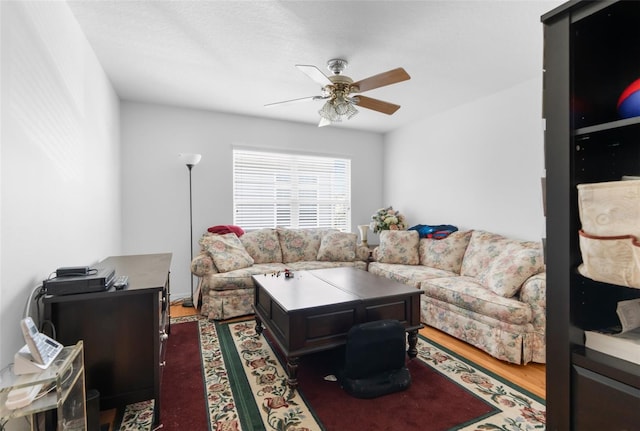 living room featuring ceiling fan and dark hardwood / wood-style flooring