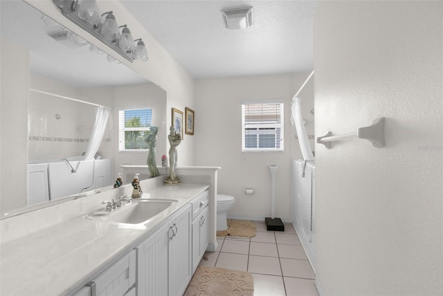 bathroom featuring tile patterned floors, vanity, a healthy amount of sunlight, and toilet