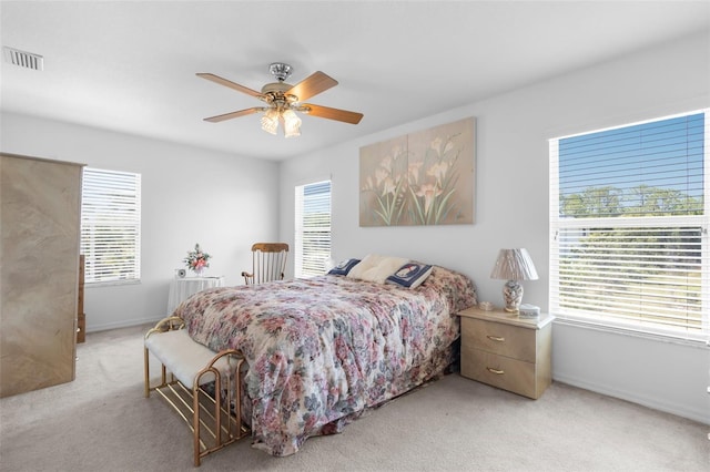 carpeted bedroom with multiple windows and ceiling fan