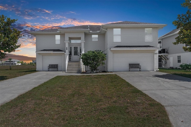 view of front of property with a garage and a yard