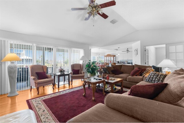 living room with hardwood / wood-style flooring, vaulted ceiling, and ceiling fan