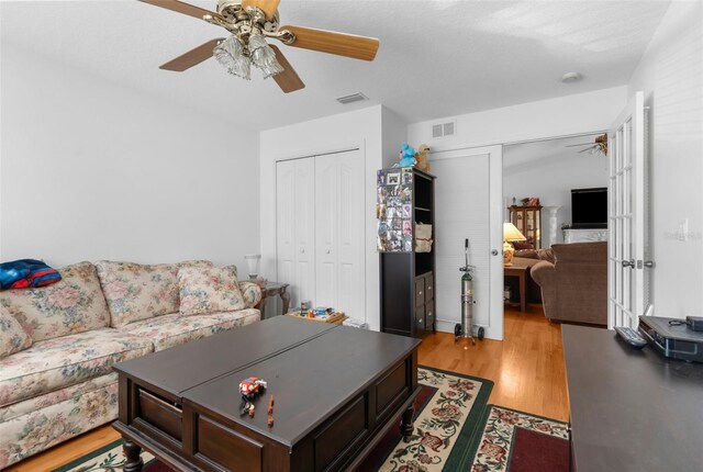 living room with ceiling fan and light hardwood / wood-style floors