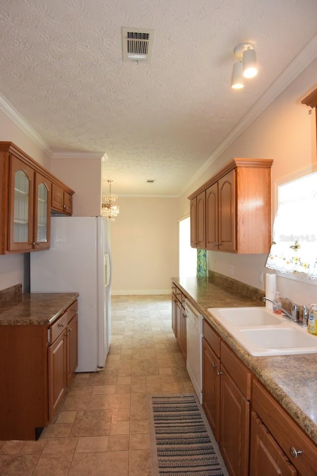 kitchen featuring ornamental molding, white appliances, sink, a notable chandelier, and hanging light fixtures