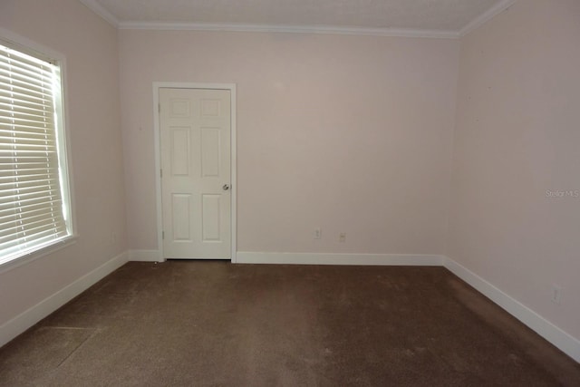 empty room with dark colored carpet and crown molding