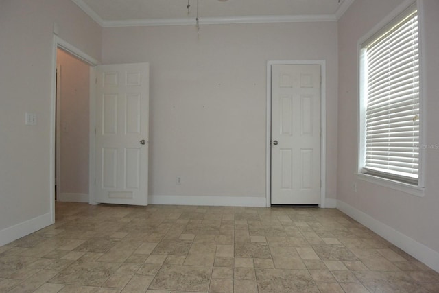 empty room featuring plenty of natural light and crown molding