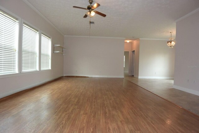 empty room featuring a textured ceiling, ceiling fan with notable chandelier, wood-type flooring, and ornamental molding