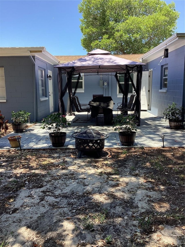 back of house featuring a gazebo, a patio, and an outdoor fire pit