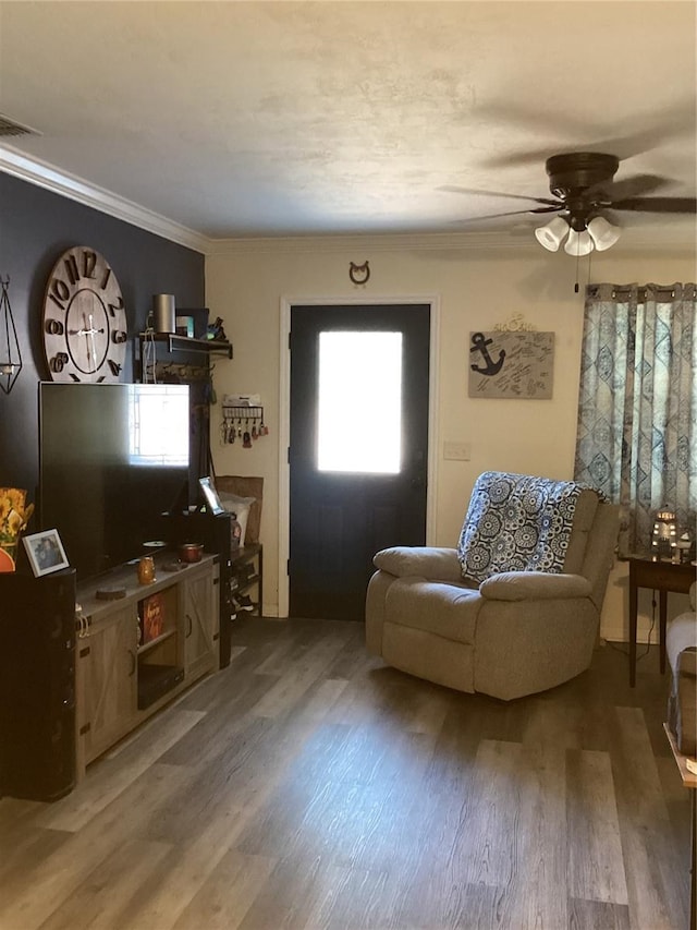 living room with hardwood / wood-style floors, ceiling fan, and ornamental molding