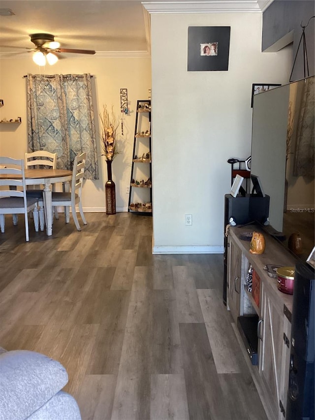 interior space featuring crown molding, dark hardwood / wood-style flooring, and ceiling fan