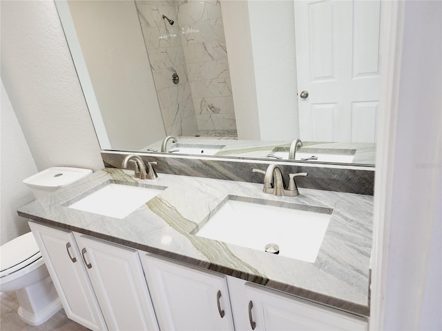 bathroom featuring tiled shower, vanity, and toilet