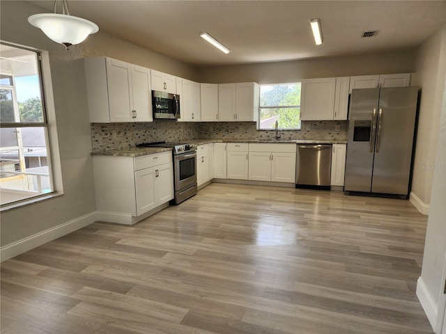 kitchen featuring pendant lighting, white cabinets, sink, and appliances with stainless steel finishes