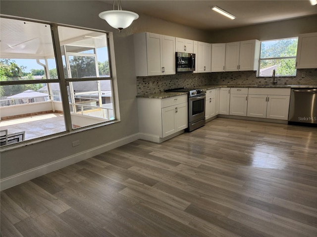 kitchen with backsplash, sink, white cabinets, and appliances with stainless steel finishes