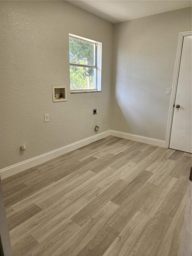 laundry room with electric dryer hookup, hookup for a washing machine, and light hardwood / wood-style floors