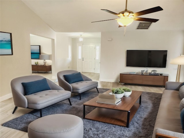 living room featuring lofted ceiling, ceiling fan, and light wood-type flooring