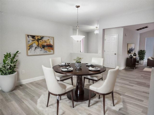 dining room with hardwood / wood-style flooring and an inviting chandelier