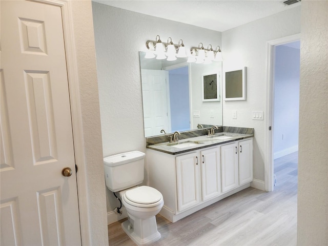 bathroom with hardwood / wood-style flooring, vanity, and toilet