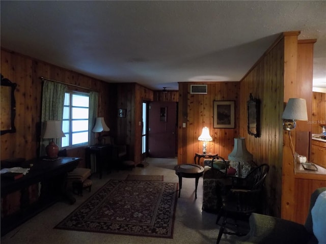 carpeted living room featuring wooden walls