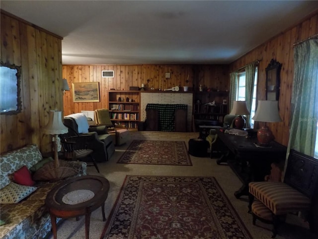 living room with wooden walls, light carpet, and a brick fireplace