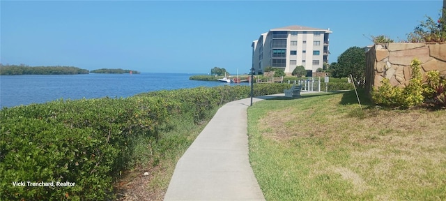 surrounding community with a lawn and a water view