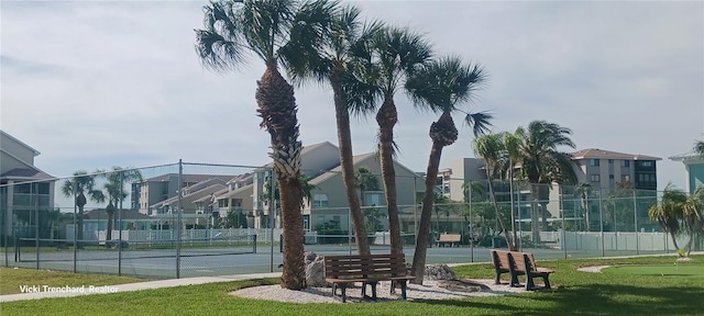 view of tennis court with a yard