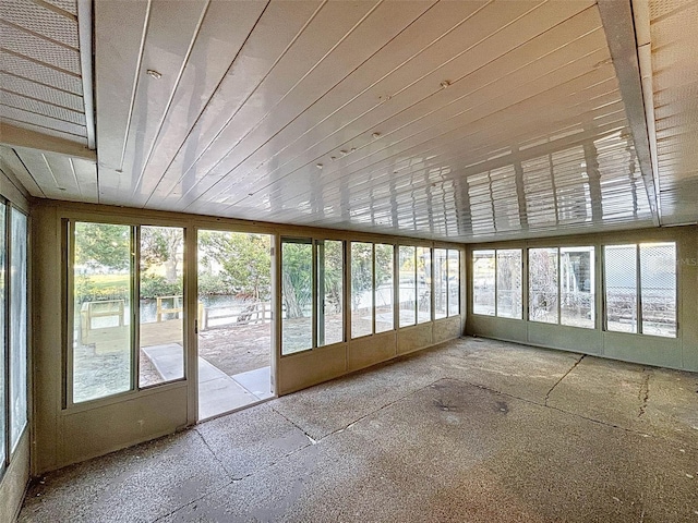 unfurnished sunroom featuring a water view