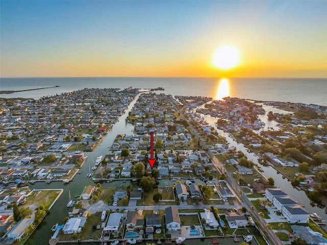 aerial view at dusk featuring a water view