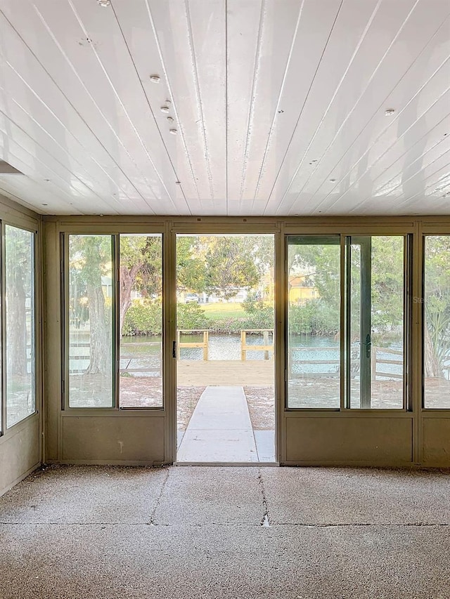 unfurnished sunroom with wood ceiling and plenty of natural light