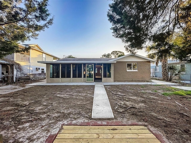 rear view of property featuring a sunroom