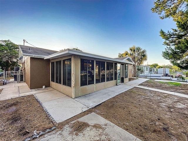 rear view of property featuring a sunroom and a patio