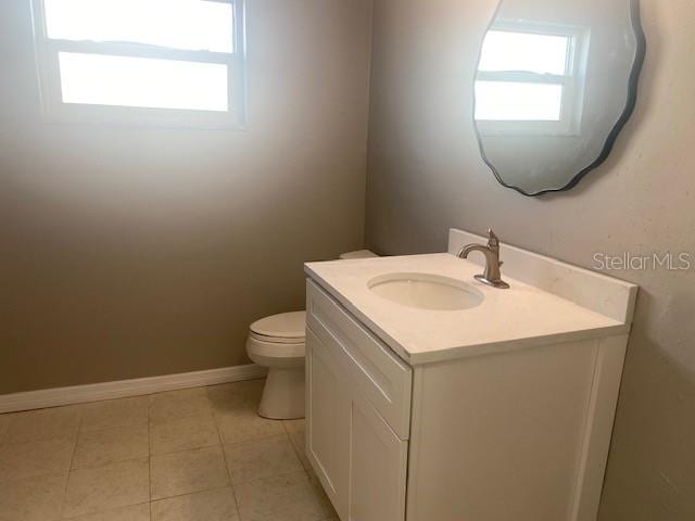 bathroom featuring tile patterned floors, plenty of natural light, toilet, and vanity