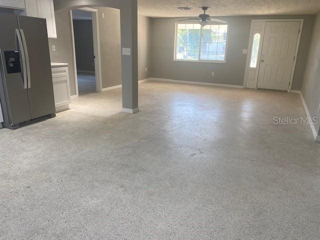 interior space with ceiling fan and a textured ceiling