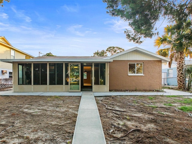 rear view of house featuring a sunroom